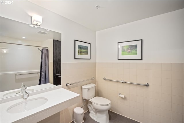 bathroom featuring toilet, tile walls, tile patterned floors, and sink