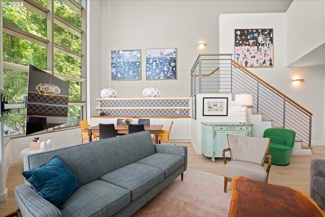 living room featuring a towering ceiling and light hardwood / wood-style floors