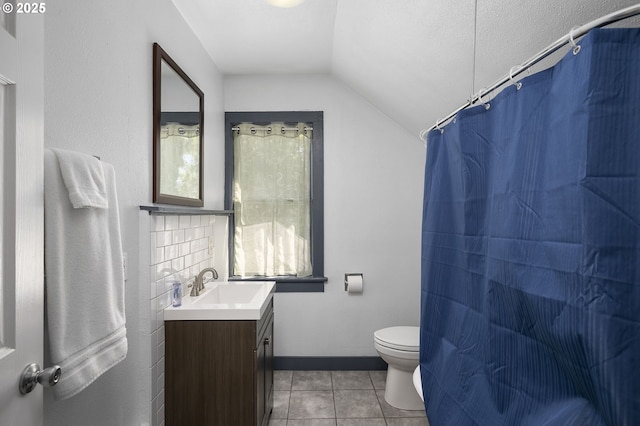 bathroom with lofted ceiling, vanity, toilet, tile patterned floors, and a textured ceiling