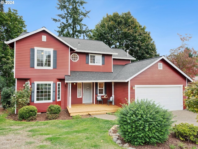 view of front of house featuring a front lawn, an attached garage, and a shingled roof