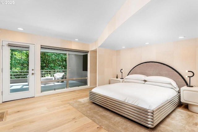 bedroom with access to exterior and light hardwood / wood-style floors