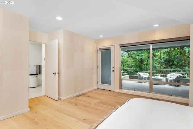 bedroom with hardwood / wood-style floors and access to outside