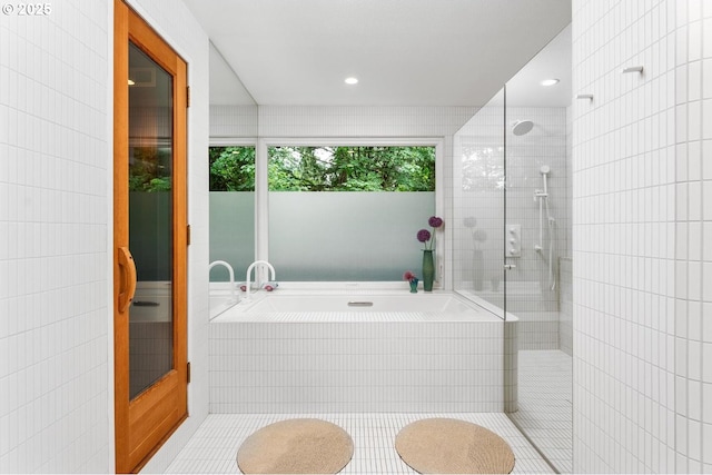 bathroom featuring tile walls, tile patterned floors, and plus walk in shower