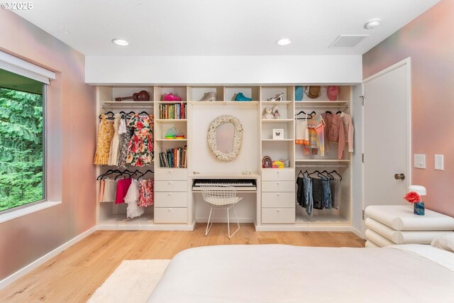 bedroom featuring built in desk and light hardwood / wood-style flooring