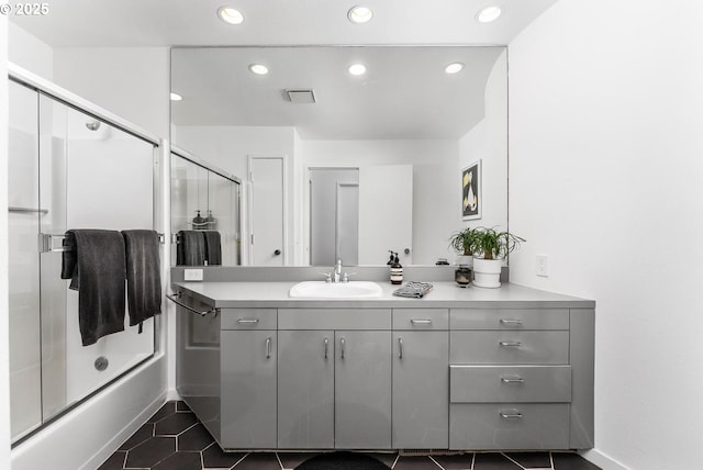 bathroom with combined bath / shower with glass door, vanity, and tile patterned flooring