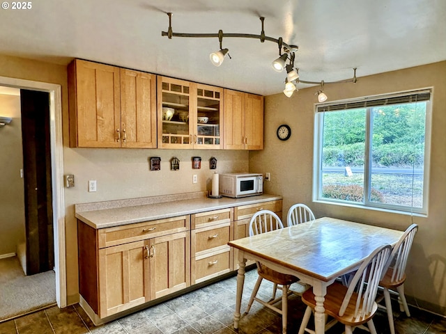 26230 Sandlake Rd, Cloverdale, OR 97112 - kitchen with white microwave, glass insert cabinets, light countertops, rail lighting, and baseboards