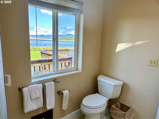 26230 Sandlake Rd, Cloverdale, OR 97112 - half bath featuring a water view, toilet, and baseboards