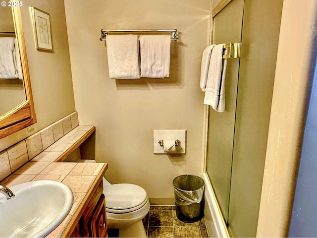 26230 Sandlake Rd, Cloverdale, OR 97112 - bathroom with baseboards, toilet, tile patterned floors, vanity, and combined bath / shower with glass door