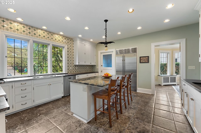 6633 SE 29th Ave, Portland, OR 97202 - kitchen featuring dark countertops, baseboards, appliances with stainless steel finishes, and a healthy amount of sunlight