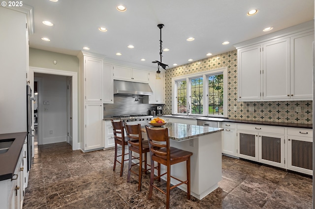 6633 SE 29th Ave, Portland, OR 97202 - kitchen featuring white cabinets, double oven range, recessed lighting, decorative backsplash, and under cabinet range hood