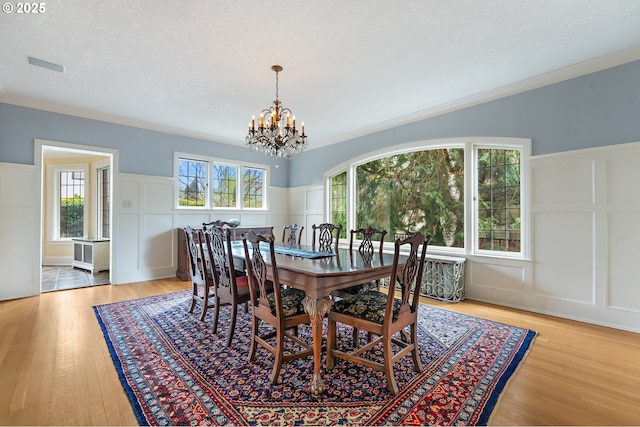 6633 SE 29th Ave, Portland, OR 97202 - dining space with a chandelier, plenty of natural light, a decorative wall, and light wood finished floors