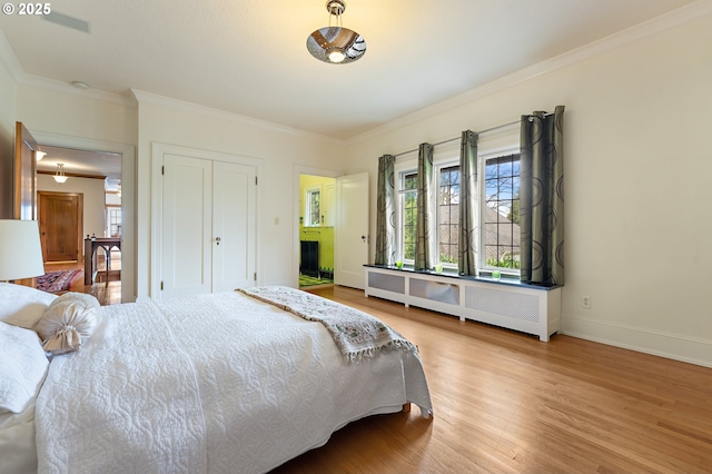 6633 SE 29th Ave, Portland, OR 97202 - bedroom featuring crown molding, wood finished floors, a closet, radiator, and baseboards