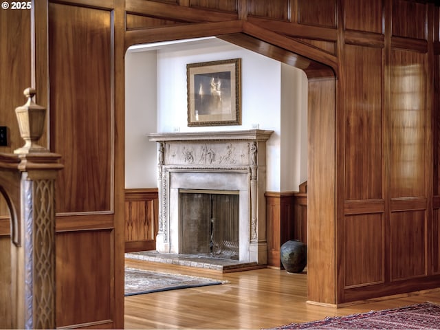 6633 SE 29th Ave, Portland, OR 97202 - unfurnished living room with wooden walls, wood finished floors, a fireplace with raised hearth, and wainscoting
