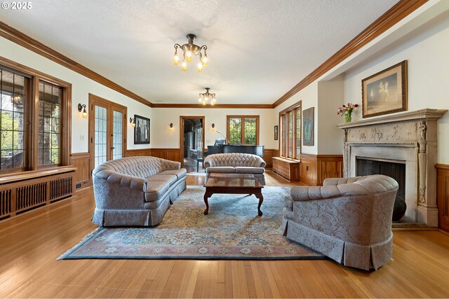 6633 SE 29th Ave, Portland, OR 97202 - living room with wainscoting, an inviting chandelier, radiator heating unit, wood finished floors, and a fireplace