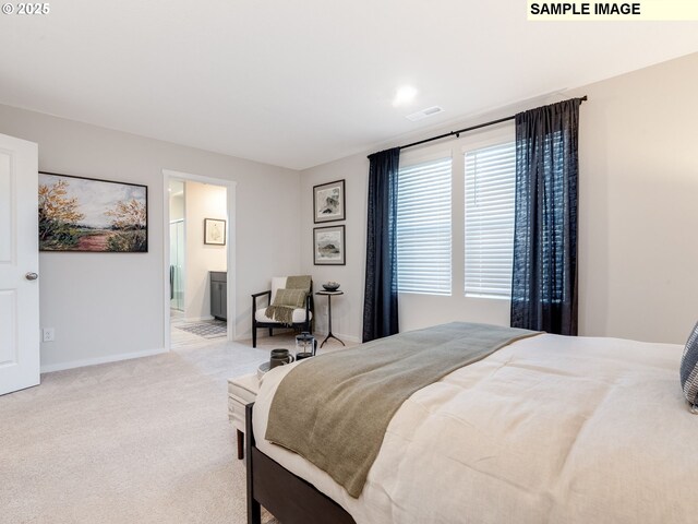 bedroom featuring light colored carpet and ensuite bath