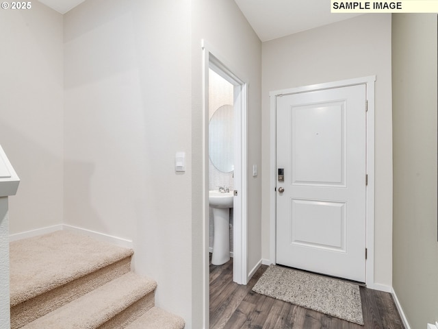 foyer featuring stairway, dark wood-type flooring, and baseboards