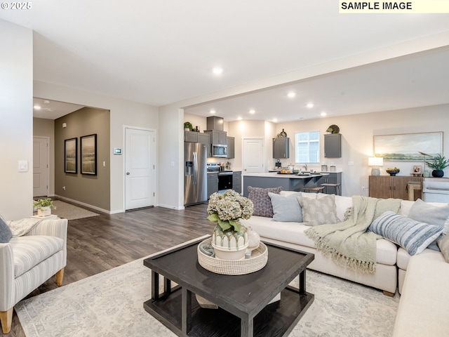 kitchen with dark wood-type flooring, appliances with stainless steel finishes, a kitchen breakfast bar, dark brown cabinetry, and a kitchen island