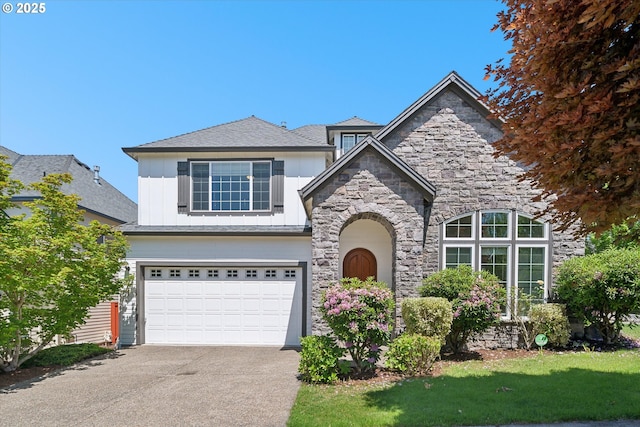 13733 NW Trevino St, Portland, OR 97229 - view of front of house with stone siding, driveway, a garage, board and batten siding, and a front yard