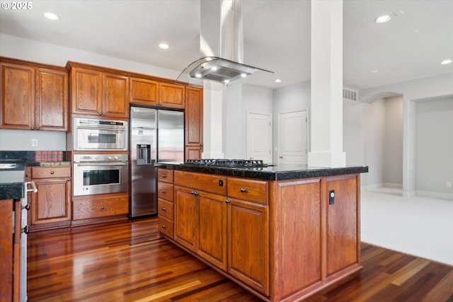 13733 NW Trevino St, Portland, OR 97229 - kitchen with appliances with stainless steel finishes, island exhaust hood, dark wood-style flooring, recessed lighting, and brown cabinetry