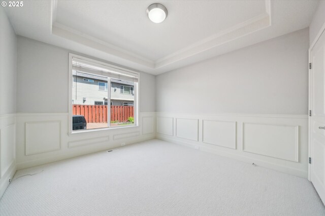13733 NW Trevino St, Portland, OR 97229 - carpeted empty room with a tray ceiling, wainscoting, a decorative wall, and crown molding