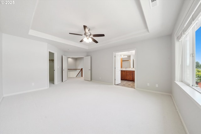 13733 NW Trevino St, Portland, OR 97229 - unfurnished bedroom with a tray ceiling, light carpet, baseboards, ensuite bath, and a ceiling fan