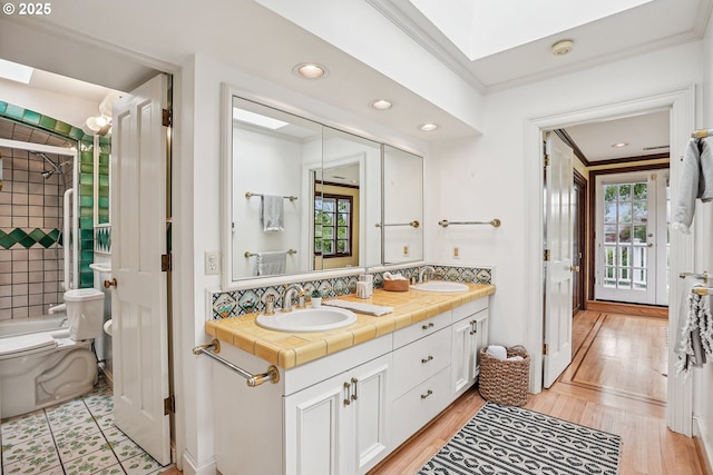 4317 SW Bernard Dr, Portland, OR 97239 - bathroom with double vanity, toilet, backsplash, ornamental molding, and recessed lighting