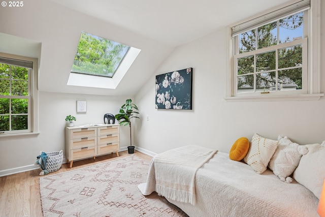 4317 SW Bernard Dr, Portland, OR 97239 - bedroom with a skylight, multiple windows, wood finished floors, vaulted ceiling, and baseboards