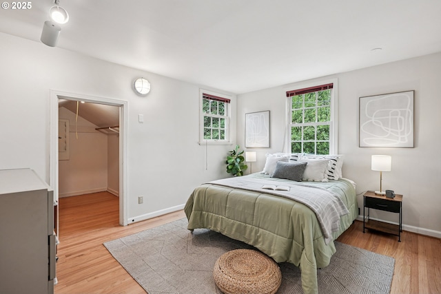 4317 SW Bernard Dr, Portland, OR 97239 - bedroom featuring light wood-type flooring, baseboards, and a spacious closet
