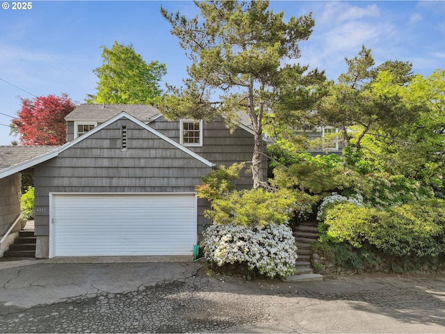 4317 SW Bernard Dr, Portland, OR 97239 - view of front of home featuring a shingled roof, asphalt driveway, and an attached garage