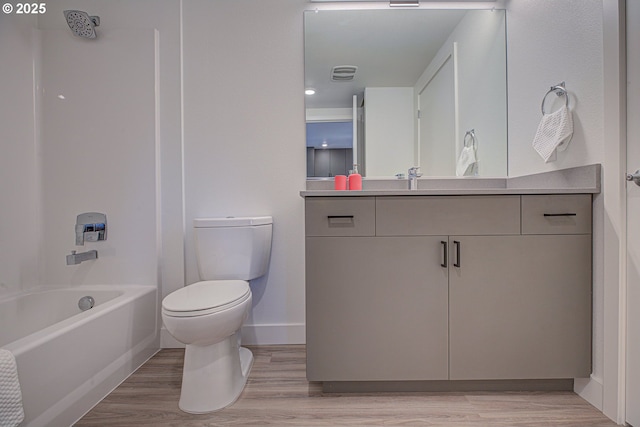 full bathroom featuring shower / bathing tub combination, vanity, hardwood / wood-style flooring, and toilet