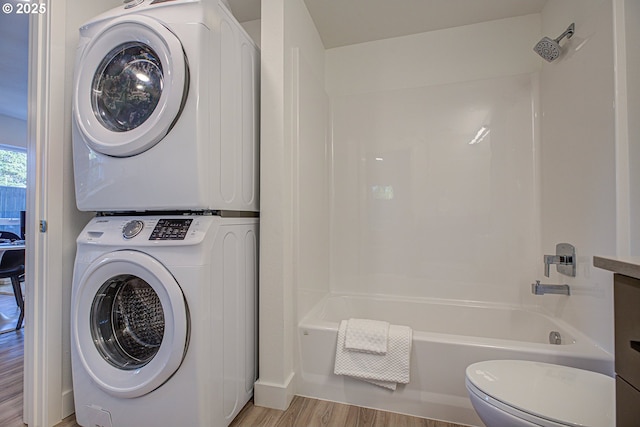 washroom featuring light wood-type flooring and stacked washer / dryer