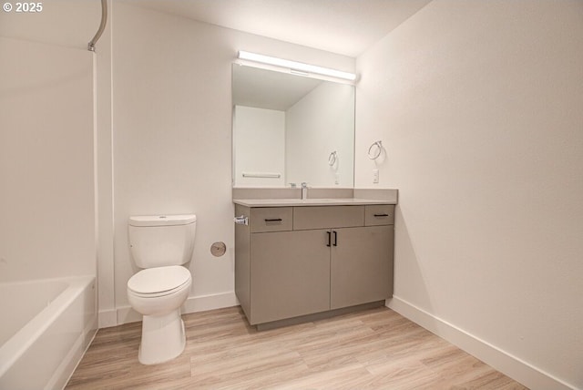 full bathroom featuring hardwood / wood-style floors, vanity, toilet, and shower / tub combination