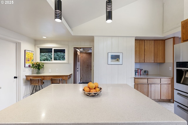 275 Sunset Dr, Eugene, OR 97403 - kitchen with brown cabinetry, a kitchen island, stainless steel fridge, lofted ceiling, and modern cabinets