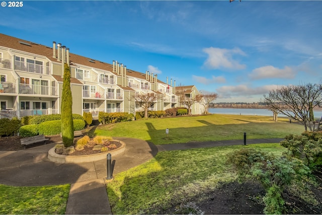 surrounding community with a yard and a water view