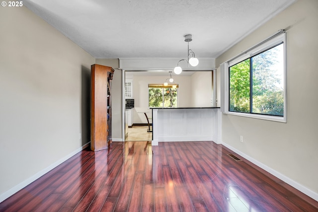 spare room featuring baseboards and wood finished floors