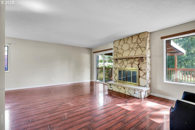 unfurnished living room featuring baseboards, a fireplace, and wood finished floors