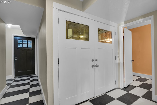 entryway with baseboards and tile patterned floors