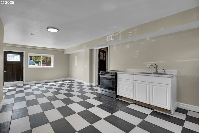 kitchen with electric range, a sink, white cabinetry, baseboards, and visible vents