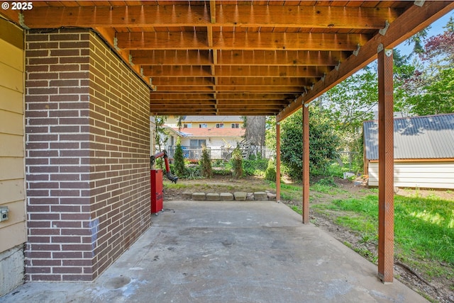 view of patio / terrace featuring fence and a carport