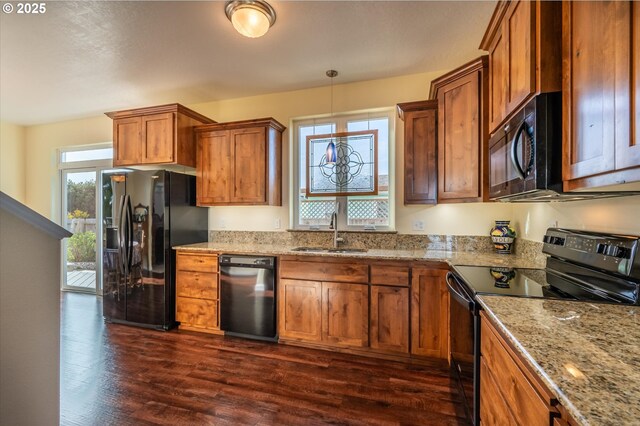 757 Newport Ave SW, Bandon, OR 97411 - kitchen with a sink, light stone countertops, brown cabinets, black appliances, and dark wood-type flooring