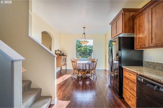 757 Newport Ave SW, Bandon, OR 97411 - kitchen with dark wood-style floors, light stone counters, pendant lighting, black appliances, and brown cabinetry