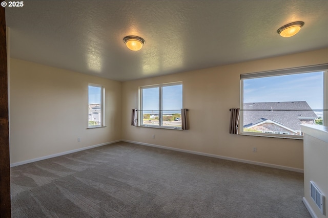 757 Newport Ave SW, Bandon, OR 97411 - carpeted empty room with baseboards, visible vents, and a textured ceiling