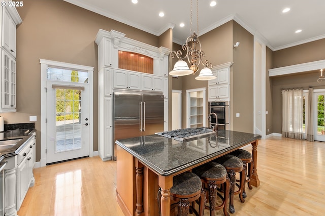 245 Winchester Creek Ave, Winchester, OR 97495 - kitchen with appliances with stainless steel finishes, light wood-type flooring, a kitchen breakfast bar, recessed lighting, and crown molding
