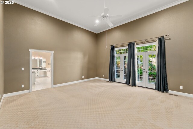 unfurnished room with a high ceiling, french doors, light carpet, ceiling fan, and baseboards
