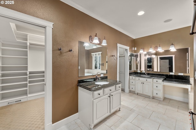 bathroom with ornamental molding, a spacious closet, tile patterned flooring, two vanities, and built in features