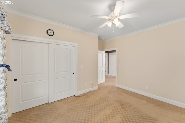 unfurnished bedroom with light carpet, ornamental molding, a closet, baseboards, and a ceiling fan