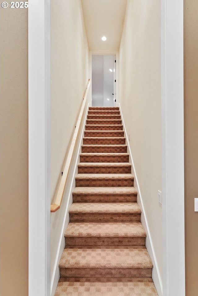 staircase featuring baseboards and recessed lighting