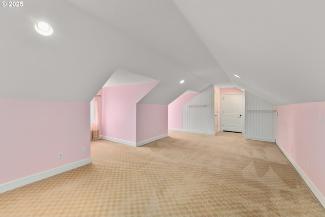 additional living space featuring light colored carpet, lofted ceiling, baseboards, and recessed lighting