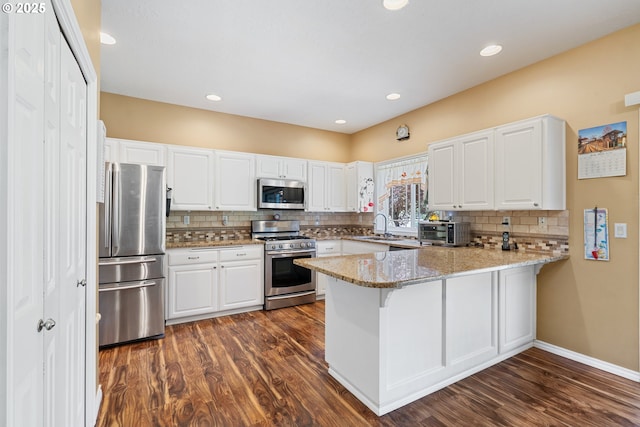 2855 NW Orchard Heights Ave, Albany, OR 97321 - kitchen with appliances with stainless steel finishes, a peninsula, a sink, dark wood-type flooring, and recessed lighting