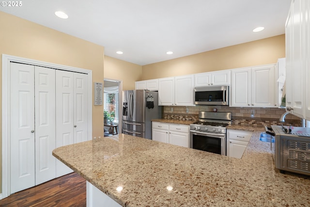 2855 NW Orchard Heights Ave, Albany, OR 97321 - kitchen with appliances with stainless steel finishes, light stone counters, tasteful backsplash, white cabinets, and recessed lighting